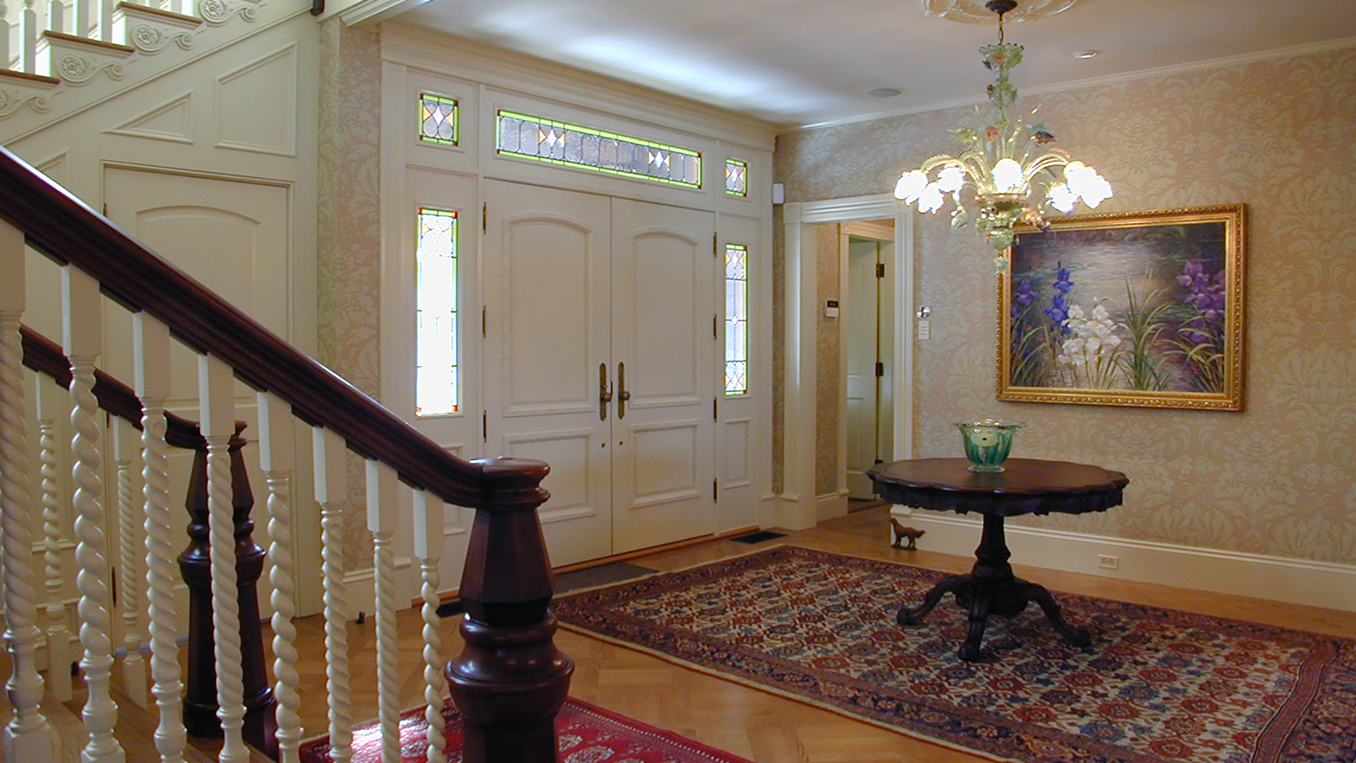 Concord Massachusetts interior of front entry with custom wood doors and stained glass sidelights